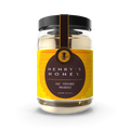 Glass jar of pure natural honey with golden honey drizzle on a wooden surface