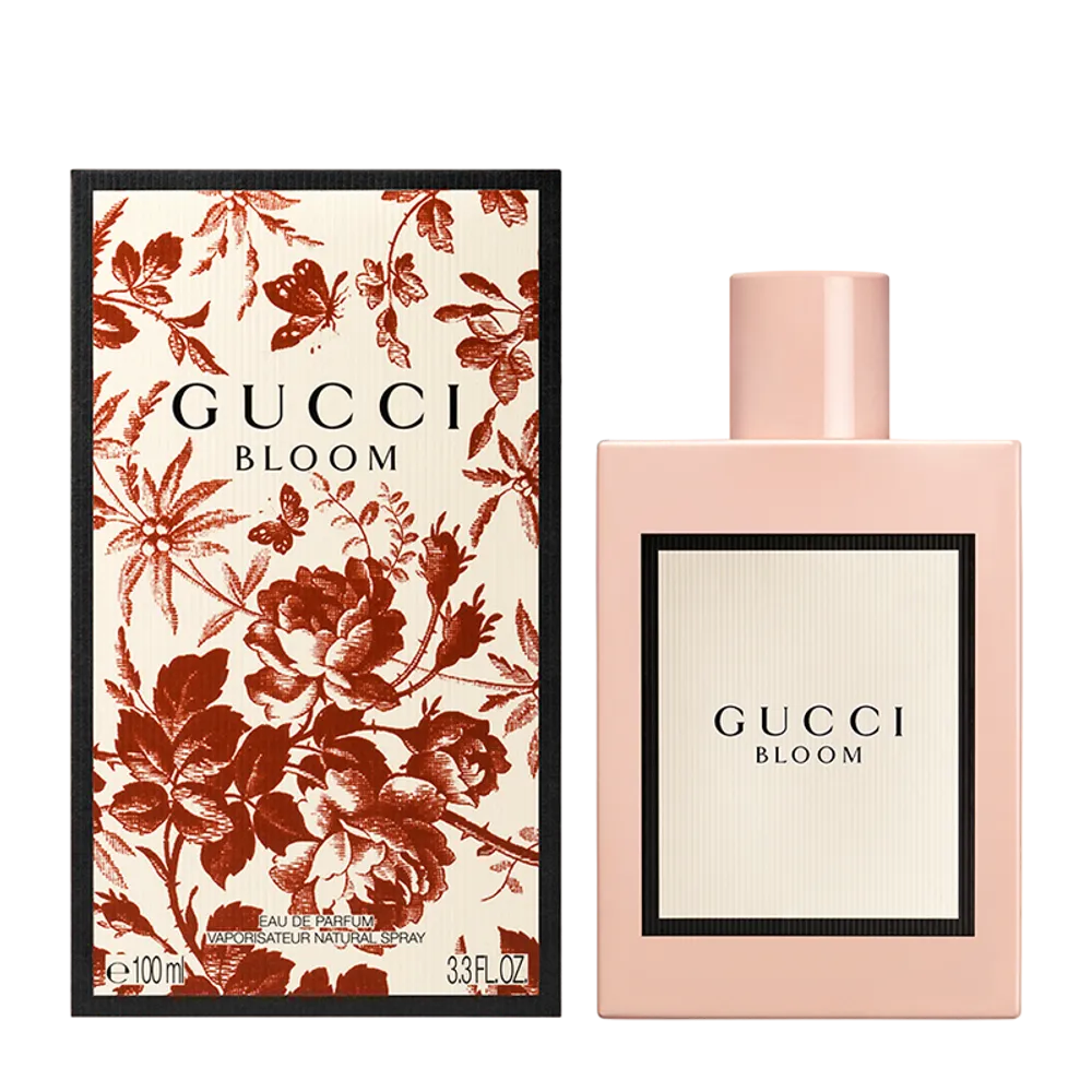 Close-up of Gucci Bloom perfume bottle showing gold cap and embossed floral label